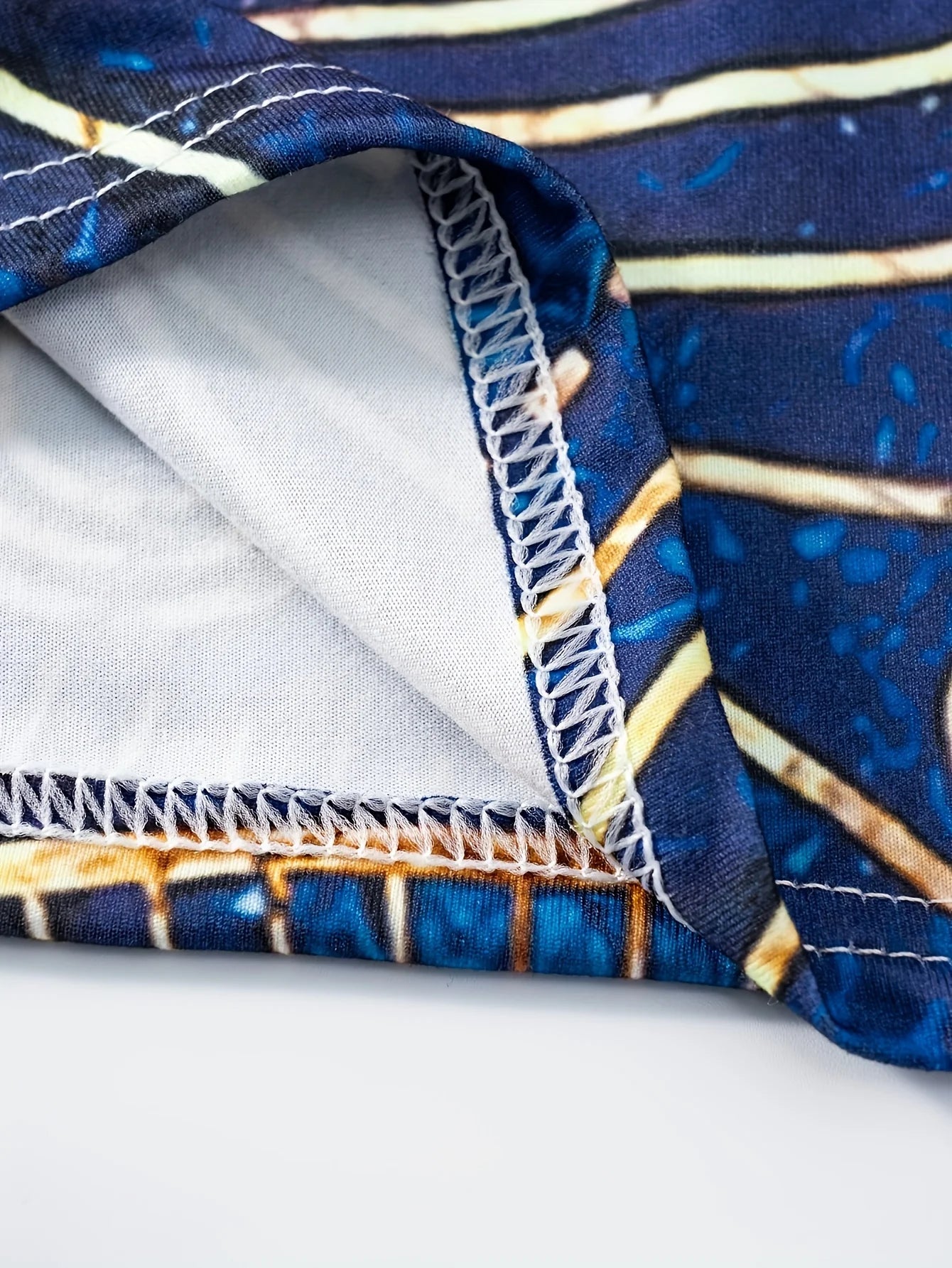 Bohemian-inspired maxi dress featuring a vibrant blue-and-gold totem print. Halter-neck, sleeveless cut with a slim fit and flow