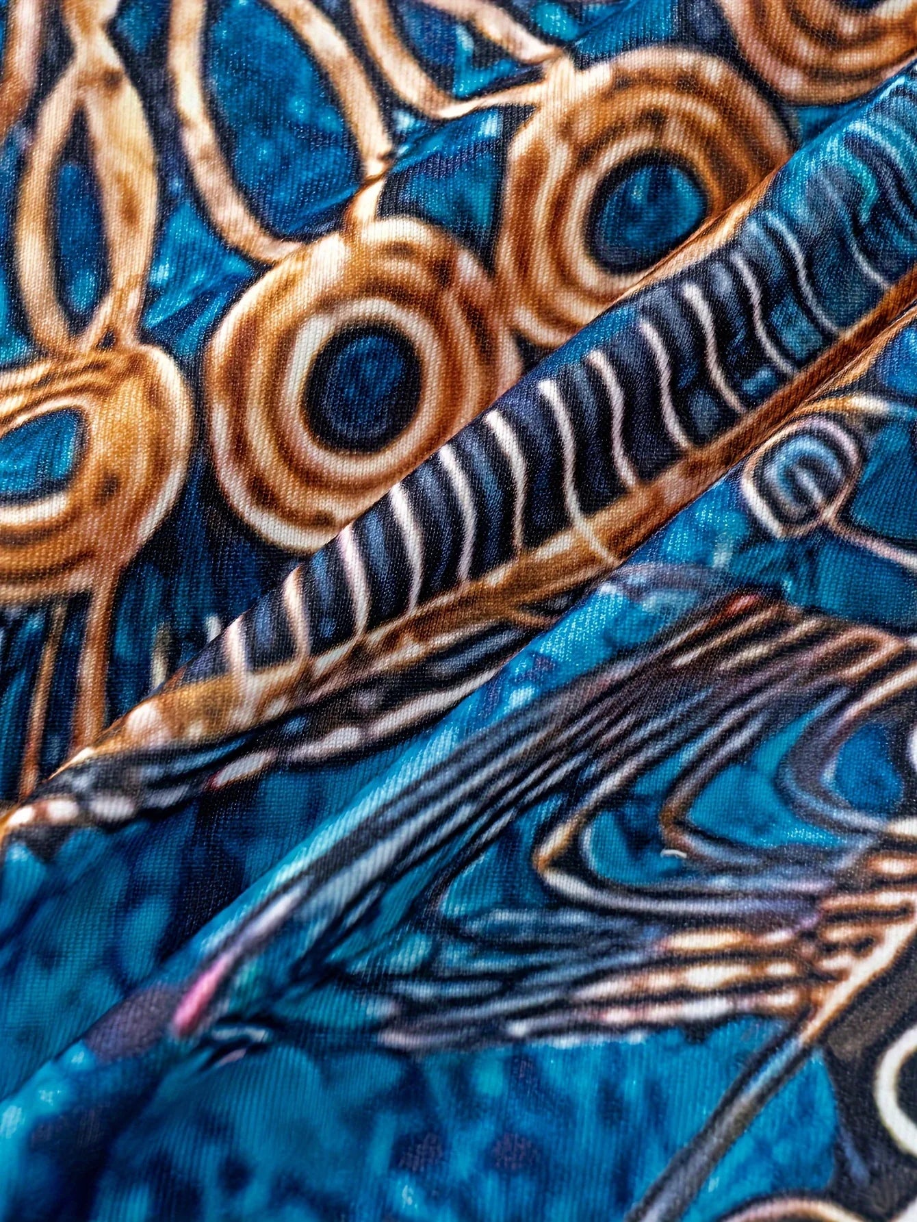 Bohemian-inspired maxi dress featuring a vibrant blue-and-gold totem print. Halter-neck, sleeveless cut with a slim fit and flow