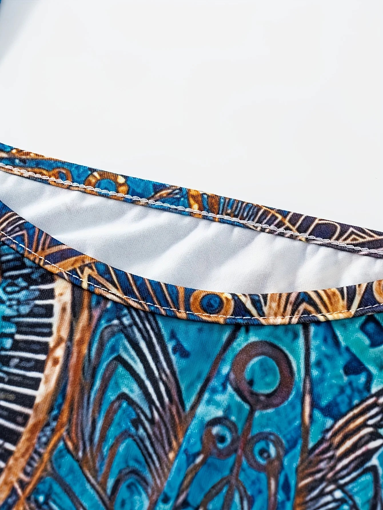 Bohemian-inspired maxi dress featuring a vibrant blue-and-gold totem print. Halter-neck, sleeveless cut with a slim fit and flow